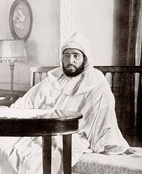 Sultan Abdelhafid seated on a settee behind a table