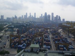 The port of Singapore with a large number of shipping containers with the skyline of the city visible in the background