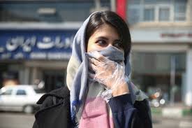 إيرانية تستخدم وشاحها ككمامة أثناء تجولها في إحدى الشوارع الإيرانية، أبريل 2020.jpg