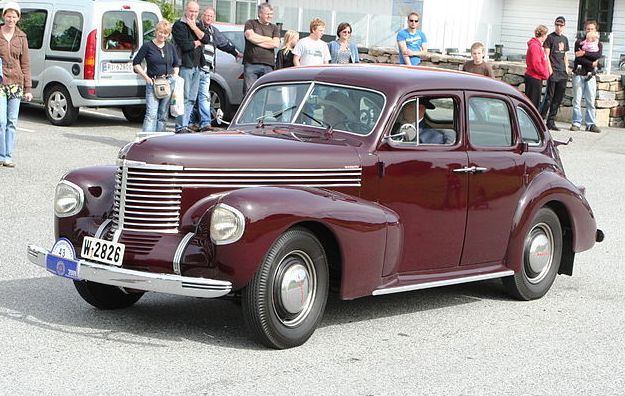 ملف:1939 Opel Kapitän, Owner Arild Nilssen who, as his lady companion wear matching attire cropped to highlight the car.jpg