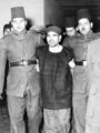Mohammed Farghali, centre, a Muslim Brotherhood leader, found guilty planning the attempted assassination of Egyptian Premier Gamal Abdel Nasser at Alexandria on Oct. 26th, is escorted to the execution chamber, in a Cairo Prison, Dec. 7, 1954, where he was hung. (AP Photo)
