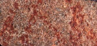 A cave wall with a number of abstract red lines drawn upon it