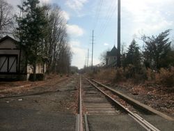 المستودع السابق لمحطة القسم الشمالي من سكك حديد إيري كما يبدو من عند تقاع طريق المقاطعة رقم 502 (هاي ستريت) في كلوستر.