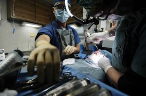 US Navy 060522-N-9389D-149 Hospital Corpsman 3rd Class Roland Alferos grabs a suture from a dental tray while assisting with oral surgery aboard USS Kitty Hawk (CV 63).jpg