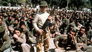 طفل ايراني مجند بالحرب يحمل سلاح رشاش