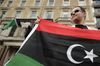 ليبي يحمل علم الثوار أمام السفارة الليبية في لندن 27 يوليو 2011.
