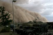 A massive sand storm cloud is about to envelop a military camp as it rolls over Al Asad, Iraq, just before nightfall on April 27, 2005.