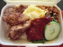 Fried chicken wing and sliced cucumber are often added to nasi lemak