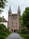 A grey stone cathedral with two towers topped with pyramidal spires.