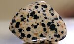 "Dalmatian jasper" – not a jasper at all but a form of the igneous rock perthite. The black spots are composed of the rare amphibole arfvedsonite (and not, as often claimed, of tourmaline). Polished pebble.