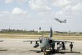 A Brazilian A-1 aircraft undergoes maintenance while a Brazilian F-2000 aircraft takes off during the CRUZEX V, or Cruzeiro do Sul (Southern Cross).