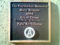 The marker under the Mary Brogger monument, vandalized with a circle-A